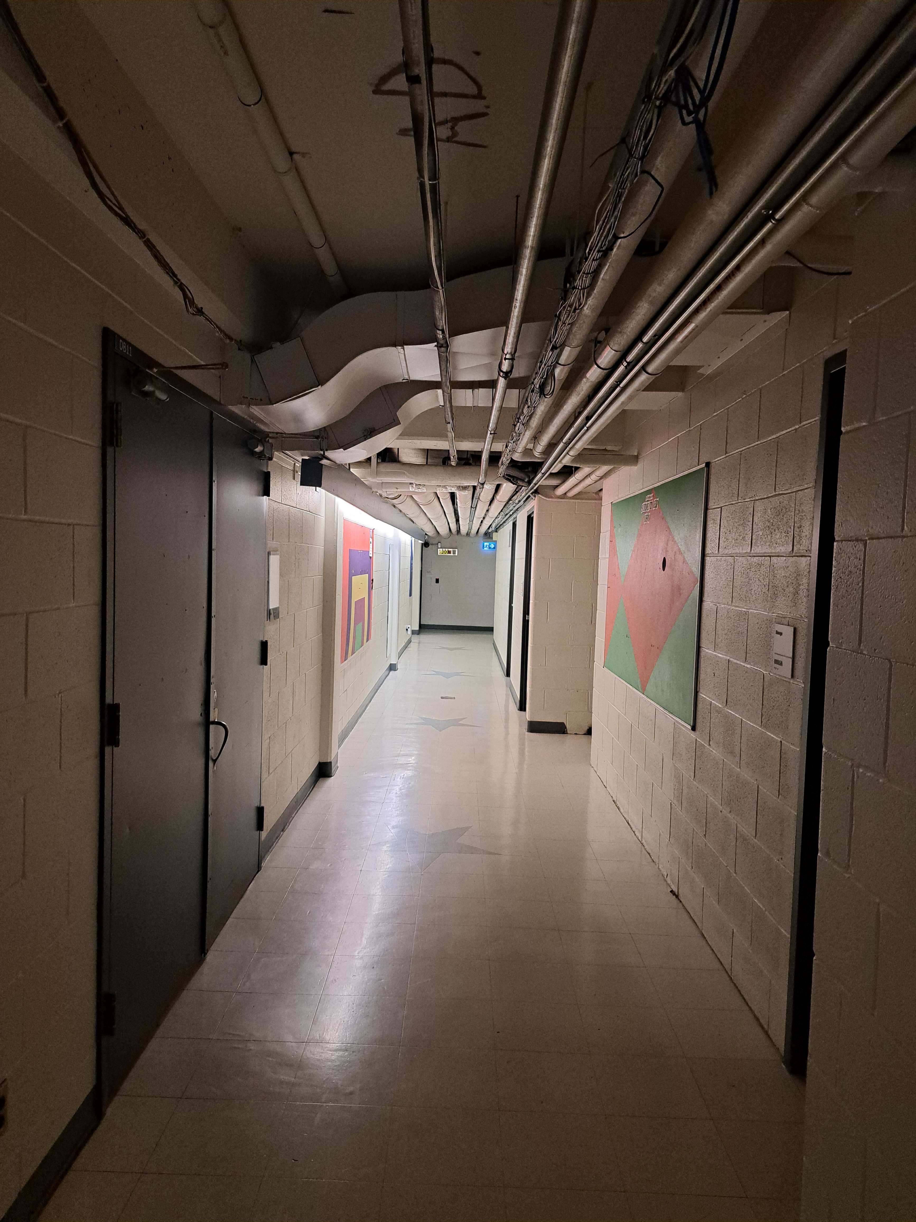 Downstairs Hall in D wing<br>Has drama classes & connects to H wing<br>Not enough lighting & exposed pipes are unsettling<br>Seems unfinished